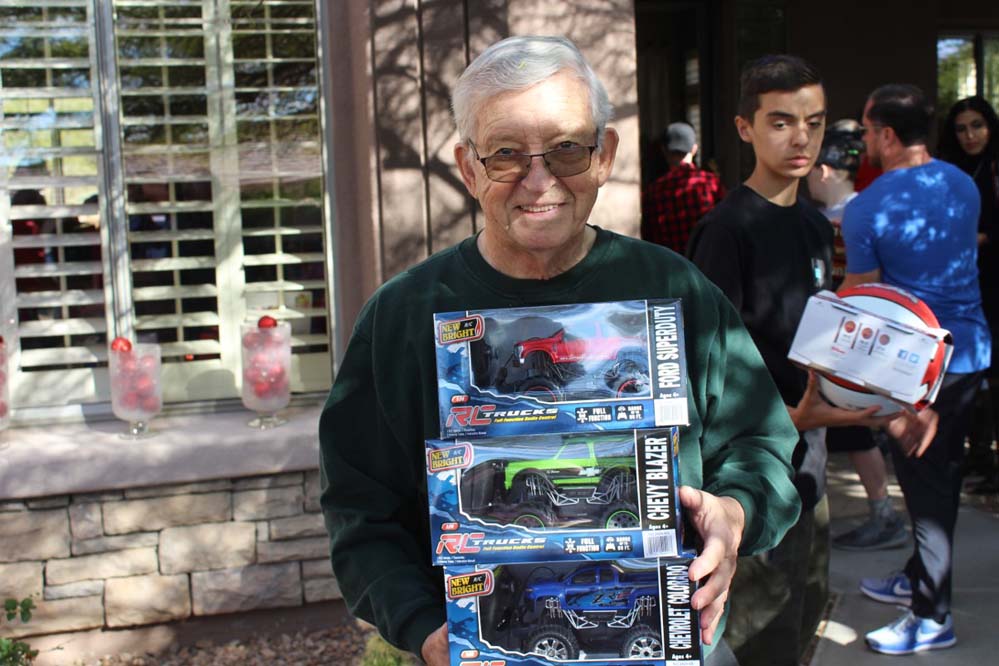 An old man with monster truck toys