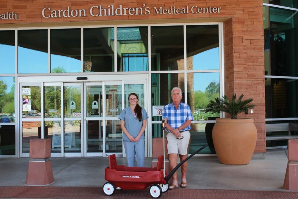 Wisconsin resident John Kaufman (and his wife Jeri) donating a IV adapted little red Radio Flyer wagon